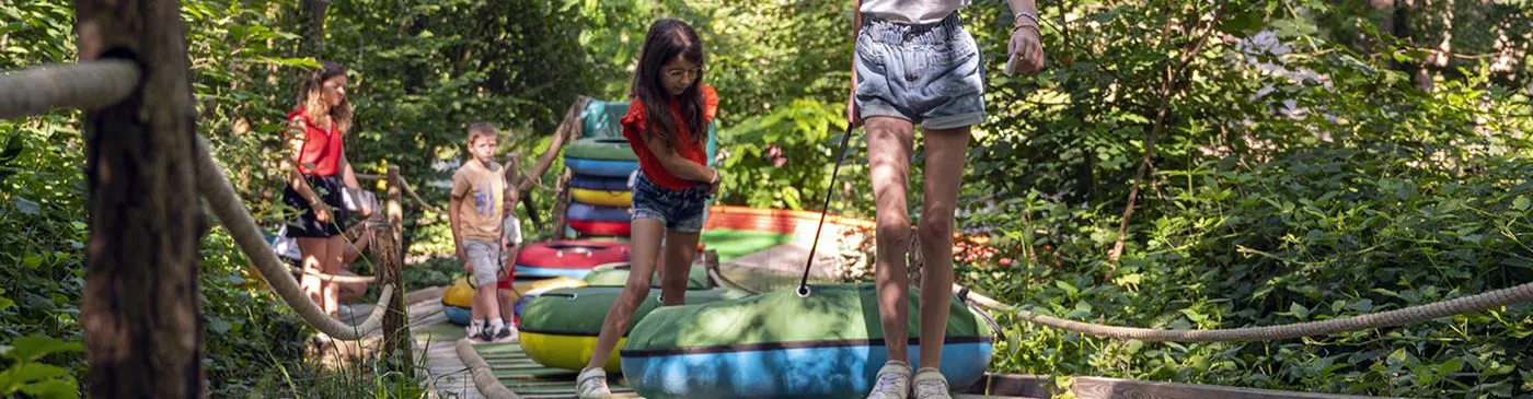 Des familles sur les jeux, au milieu des arbres